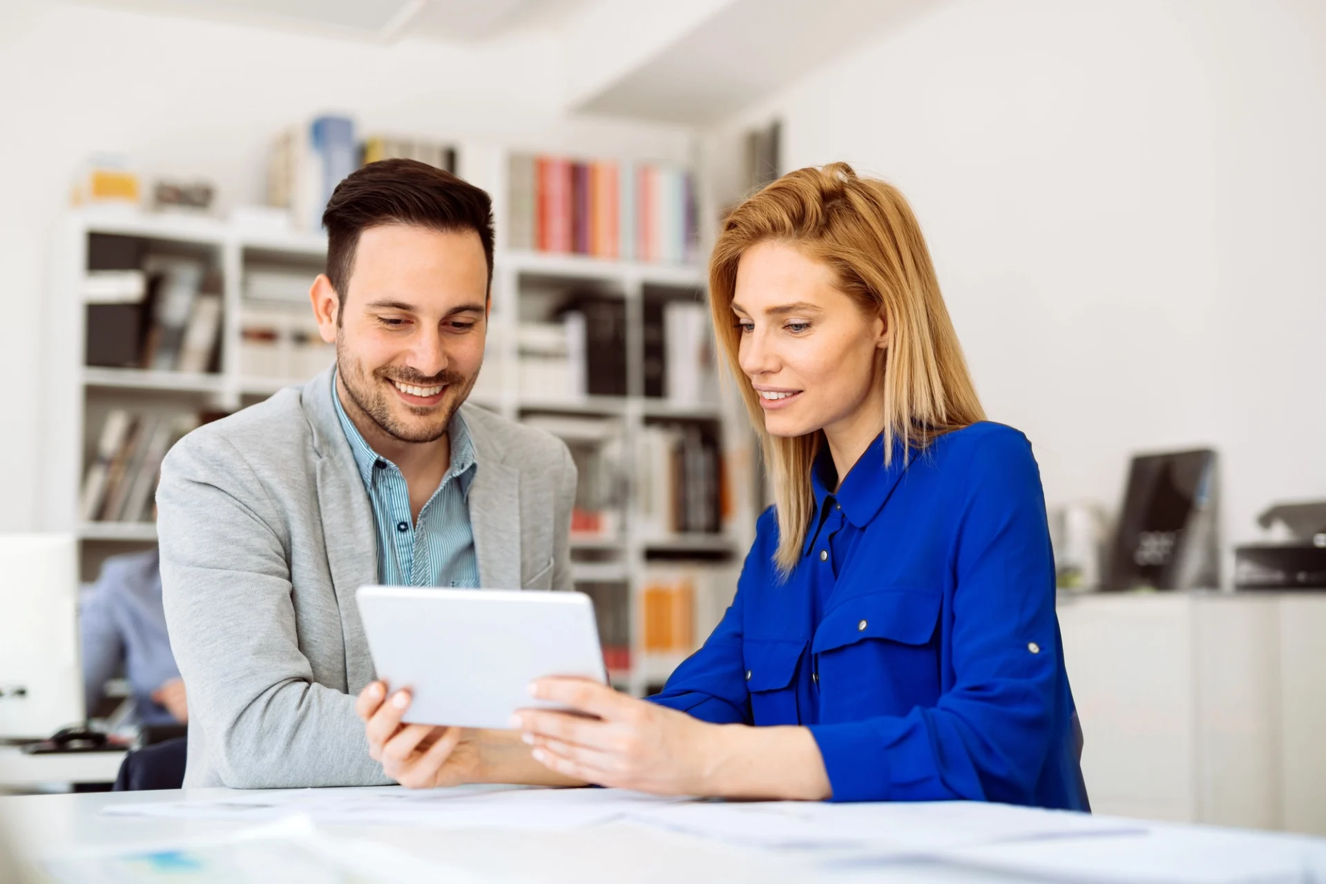 Two colleagues reviewing dental billing figures on a tablet